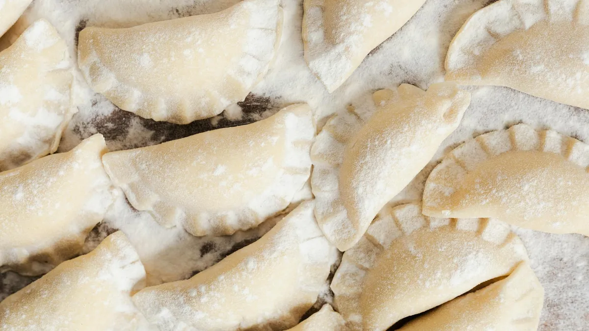 Pierogi polacos rellenos de queso y patata con cebolla caramelizada y nata agria